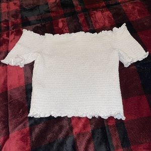White crop top. This crop top is a tighter fit and is off the shoulders.